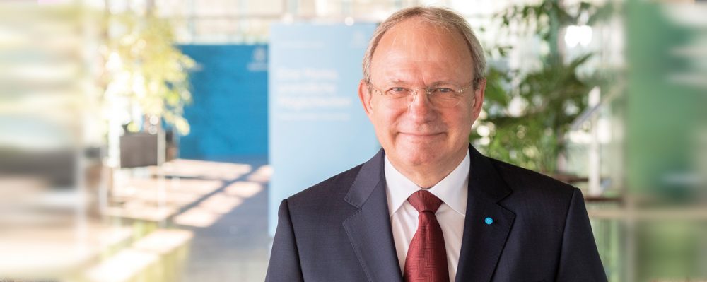 Portraitbild Dr. Ing. Jens Reichel mit blauem Anzug und roter Krawatte