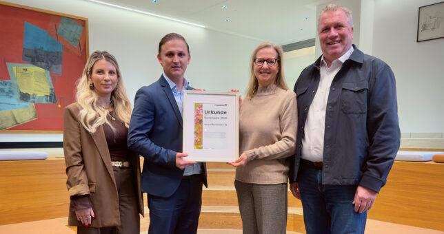 Vertreter der Piepenbrock Niederlassung Köln überreichen eine Urkunde an seinen Geschäftskunden General Reinsurance AG Köln.