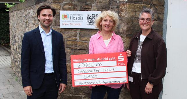 Lasse Pötter und Daniela Kuhlmann von Piepenbrock übergeben einen symbolischen Spendencheck an Anja Hanke, Koordinatorin Öffentlichkeitsarbeit beim Osnabrücker Hospiz e. V. (Mitte)