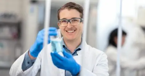 Planol Mitarbeiter in Schutzkleidung im Labor mit Reinigungsmittel in Reagenzglas