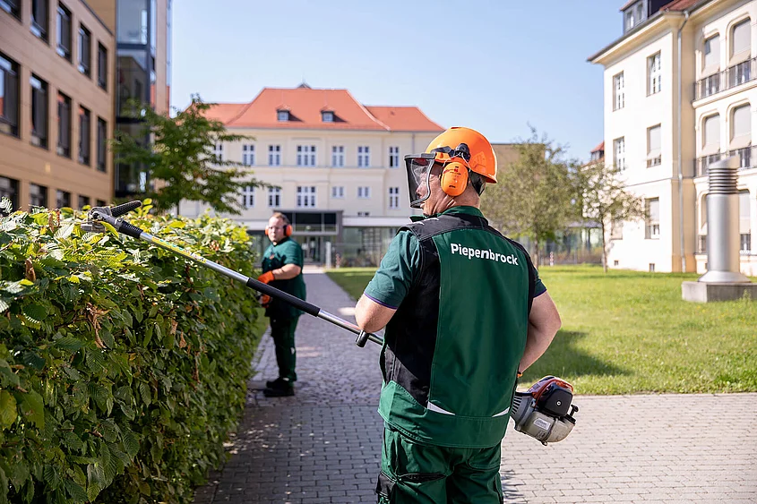 Piepenbrock Grünanlagenpflege Mitarbeiter der Piepenbrock Grünanlagenpflege schneiden eine Hecke