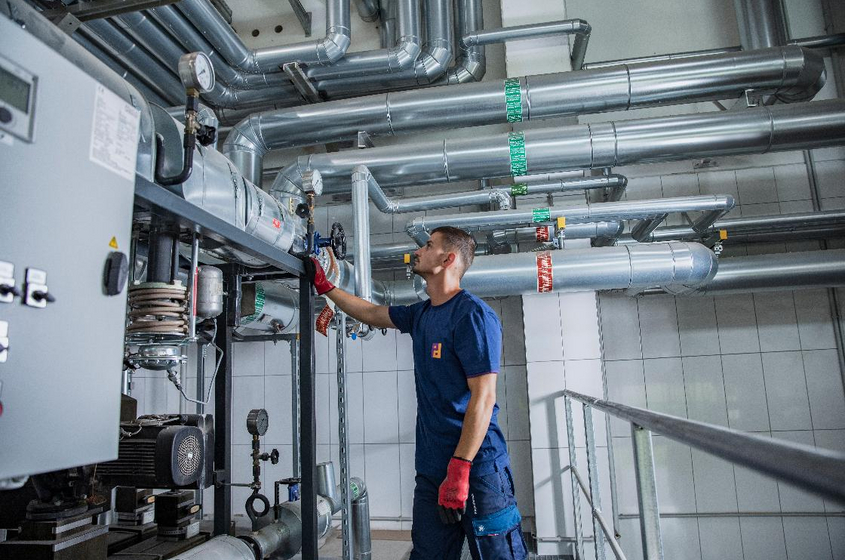 Mitarbeiter begutachtet ein Rohrsystem in einem Maschinenraum