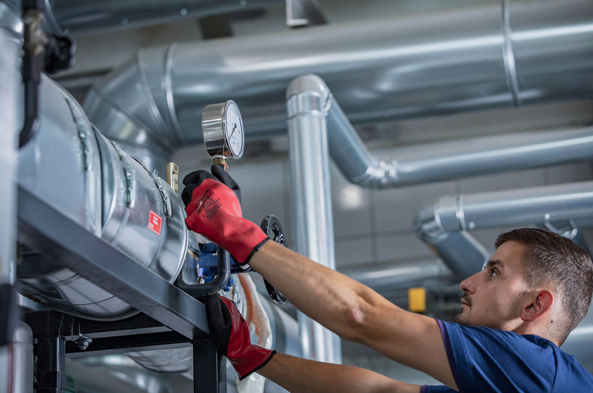 Mitarbeiter führt Pressenprüfung durch