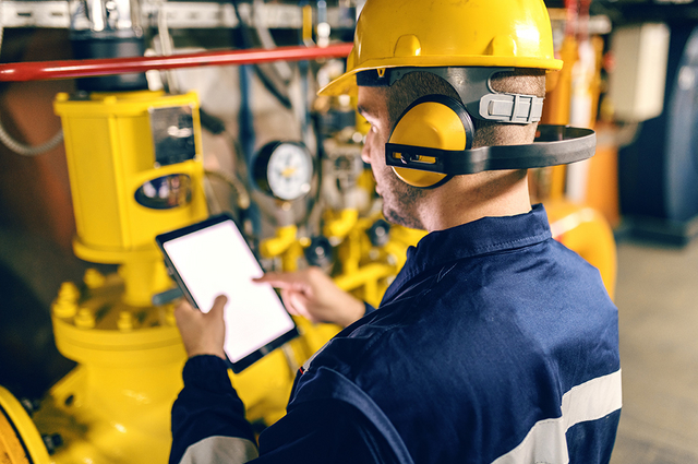 Mitarbeiter führt Druckluft-Leckageortung mit speziellen Geräten durch