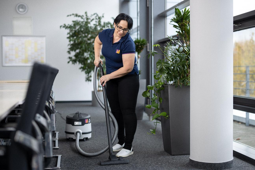 Frau saugt Konferenzraum
