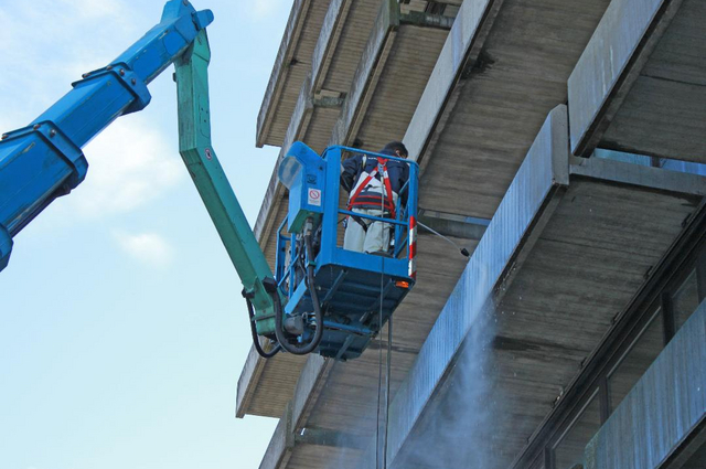 Mitarbeiter der Piepenbrock Fassadenreinigung säubert Gebäudefassade
