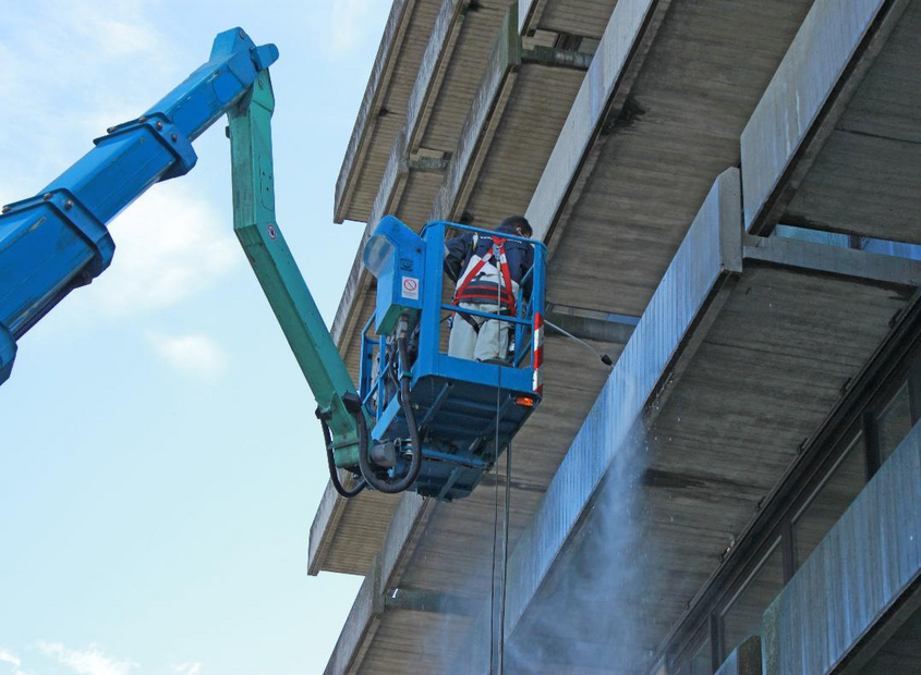 Mitarbeiter der Piepenbrock Fassadenreinigung säubert Gebäudefassade
