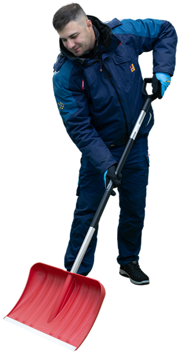 Mann in blauer Winterjacke mit Piepenbrock Logo räumt draußen Schnee mit rotem Schneeschieber.