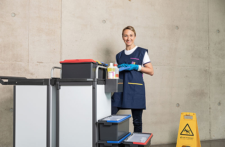 Frau im Gang mit Reinigungswagen