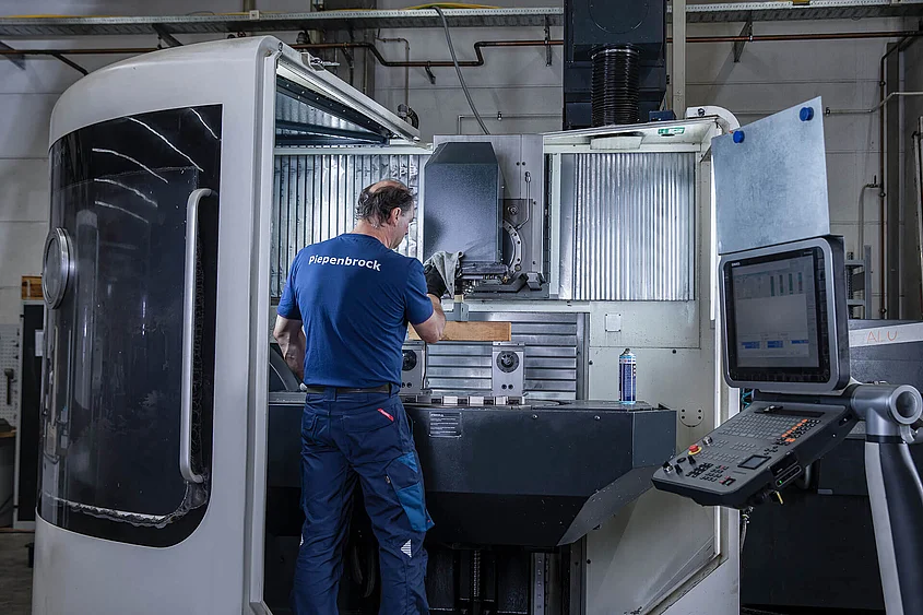 Piepenbrock Werkzeugmaschinen Piepenbrock Mitarbeiter reinigt eine Werkzeugmaschine