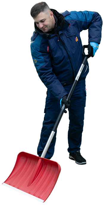 Mann in blauer Winterjacke mit Piepenbrock Logo räumt draußen Schnee mit rotem Schneeschieber.