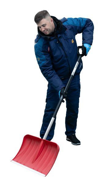 A man in a blue winter jacket with the Piepenbrock logo is shoveling snow outside with a red snow shovel