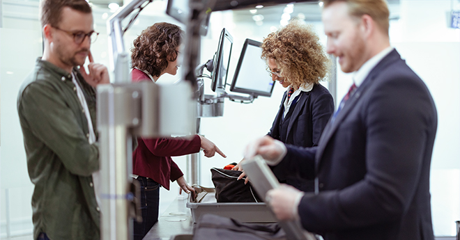 Vier Personen an der Sicherheitskontrolle am Flughafen